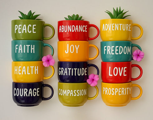 Colorful mugs with motivational words and small plants on a light background