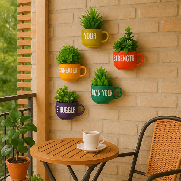 Colorful mugs with plants on a wall next to a table with a white mug.